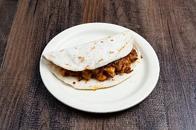 A folded flour tortilla taco filled with chorizo and diced potato.